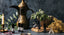 A series of brass plates, bowls, and pots on a grey surface, surrounded by essential oil bottles and fresh leaves